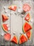 Watermelon juice or smoothie with ice cube and sliced watermelon fruit on rustic wooden background, top view