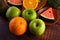 Watermelon, oranges, cut into pieces with avocado and apples on wood table