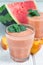 Watermelon, peach, mint and coconut milk smoothie in glass on white wooden background, vertical