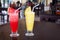 Watermelon and pineapple shakes close up, sliced fruits pieces, straw, two fruit shakes with garnish in transparent glasses