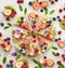 Watermelon pizza with various fresh fruits with the addition of cream cheese, mint and edible flowers. A delicious fruity dessert