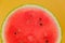 Watermelon pulp close-up. Watermelon cut on a yellow background.Fresh red watermelon half. Appetizing summer fruits.