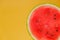 Watermelon pulp close-up. Watermelon cut on a yellow background.Fresh ripe red watermelon half. Appetizing summer fruits