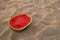 A watermelon on the sandy beach on the sunset.