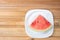Watermelon in slice on a white crockery on wood, top view