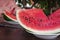 Watermelon slice in white plate, man eating in the background