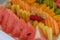 Watermelon slices in front of colourful fruits