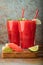 Watermelon slushie with lime, summer refreshing drink in tall glasses on a blue rusty background