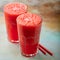 Watermelon slushie summer refreshing drink in tall glasses on a blue rusty background