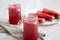 Watermelon smoothie in glass jars with fresh slices of water melon over white wooden surface, side view. Closeup