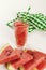 Watermelon smoothie in a glass, on a white table, with a green napkin. Copy space