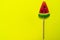 Watermelon wedge lollipop on bright yellow background. Copy space.