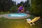 A waterpool with chair near wooden house at night