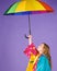 Waterproof accessories for children. Kid girl happy hold colorful umbrella wear waterproof cloak. Enjoy rainy weather