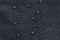 Waterproof droplets on fabric. Black Canvas Polyester texture synthetical for background. Black polyester textile backdrop for