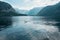 Waterscape of swan swimming in lake with lots of reflection in water and big mountains in background, Salzburg, Austria