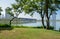 Waterside grassy lawn in summer morning with TICC across lake