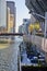 Waterside patio on Chicago canal with tour boats passing under bridge with line of skyscrapers