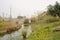 Waterside pitched and thatched building in weeds