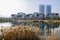 Waterside reeds with modern buildings in distance on sunny winter day