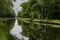 Waterways in Belgium, manmade canal with oak trees alley