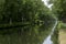 Waterways in Belgium, manmade canal with oak trees alley