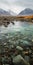 Watery Rocky Pond With Mountains In Light Turquoise And Amber