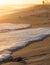 Wave breaking on the beach forming white foam