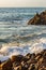 Wave breaking on rocks at shoreline with sunrise