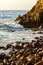 Wave breaking on rocks at shoreline with sunrise