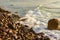 Wave breaking on rocky shore curving into distance