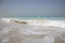 Wave breaking in turquoise waters on a white sand beach