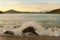 Wave breaks over rock on beach, Indonesia