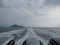 Wave bubble behind speed boat with clouded sky