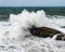 Wave crashing on rock by a stormy day