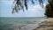 Wave crashing the sandy beach under sunny blue sky