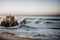 A wave cresting over a sandcastle crumbling the towers