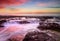 Wave flows over weathered rocks and boulders