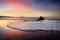 Wave foam on beach at sunset