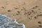 Wave hits beach with colorful pebble stones - closeup