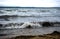 Wave rolls over the sandy shore of lake Uvildy