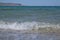 A wave on the sandy shore of the Aegean Sea.