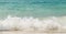 Wave of the sea swashing up onto sand beach, summer background