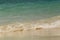 Wave of the sea swashing up onto sand beach, summer background