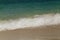 Wave of the sea swashing up onto sand beach, summer background