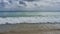 A wave of surf rolls onto the beach.