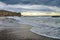 Wave of the surf on a sandy beach in cloudy weather. Crimea, Sudak