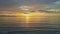 Wave surf on serene ocean beach sun rises above horizon