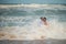 Wave swept the newlyweds. Bride and groom posing in the sea