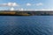 Waveless calm water surface with a grass-covered landscape view on the horizon